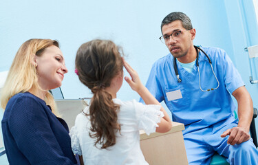 Fototapeta premium Medical examination of little girl by african doctor