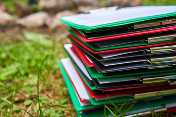 Stack of pads with documents on the grass 