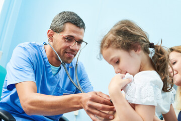 Pedeatrician african doctor examining little girl with stethoscope