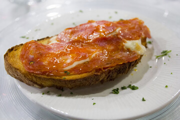 Italian bread (crostino) with mozzarella and spicy salami - 366984076