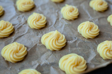 Bignè alla panna all'italiana. Profiteroles al cioccolato fondente. Preparazione a mano prima della cottura al forno.
