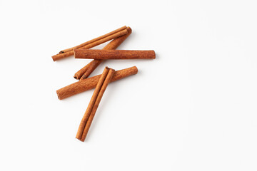 Cinnamon sticks on white background, place for text