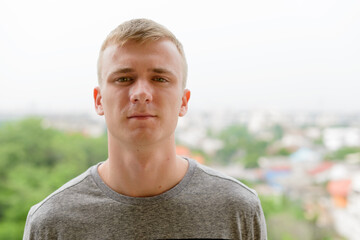 Portrait of young man with blond hair outdoors