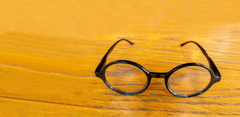 Top front view of round shape eyeglasses on dark wood background