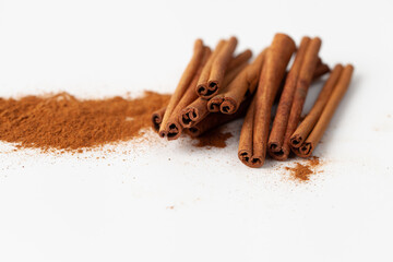 Cinnamon sticks and ground cinnamon on a white