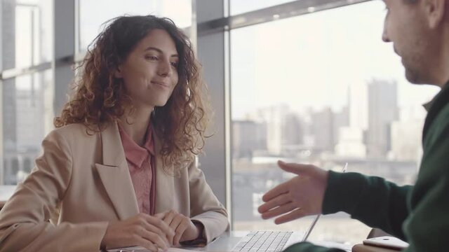 Lockdown of Caucasian businesswoman and businessman finishing discussion and shaking hands. Then man going away and woman continuing working