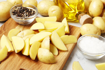 Composition of young potatoes, spices, butter, kitchen utensils. Cooking concept. on a colored background with place for text