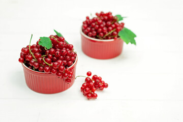 Red currant berries in a cocotte on a white background. Natural vitamins concept.
