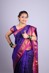 Beautiful Indian girl showing thumbs up as a sign of good luck or all done.