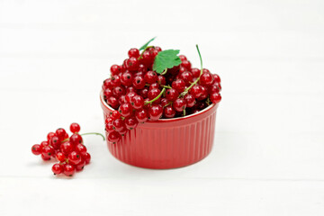 Red currant berries in a cocotte on a white background. Natural vitamins concept.