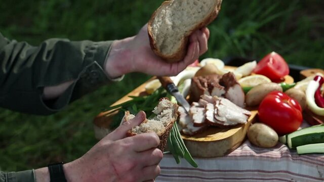 picnic in nature a tourist breaks off a piece of bread on a fishing trip