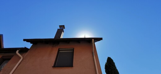 Altes Haus mit Schornstein vor blauem Himmel