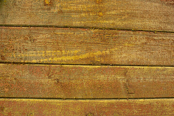 Old tumbledown weathered wood boards background with peeled yellow paint, shabby rustic brown barn timbered siding aged withered faded flooring surface. Obsolete wall blank abstract rustic texture.