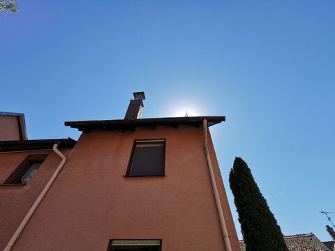 Ein altes Haus mit Schornstein vor blauem Himmel