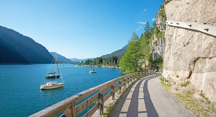 bike way along lakeside Achensee east with mountain view and sailboats