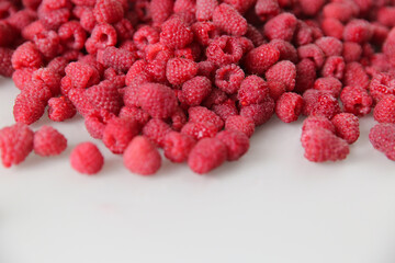 a lot of raspberries on a white background, close-up, red, ripe, free space, place for an inscription