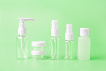 Set of empty travel women toiletries beauty kit on vivid green background. Approved for airplane luggage bottle container size. Isolated with copy space for text for beauty social media