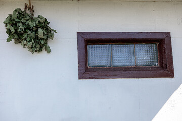 Birch broom for a bath, lead on a white wall, for drying
