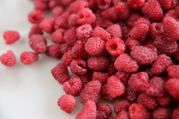 a lot of raspberries on a white background, close-up, red, ripe, free space, place for an inscription