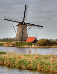 Fototapeta premium Kinderdijk, Netherlands; A working windmill at Kinderdijk