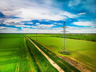 Fototapeta na wymiar Electric pole in an autumn summer field at sunrise with aerial shooting