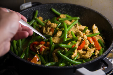 Sprinkling fresh coriander over a delicious chicken tikka masala with Indian spices