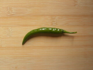 Green color raw whole Chili pepper on wood background