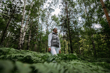 young woman deep in siberian forest with fern around