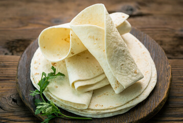 Whole wheat flour tortilla on the wooden table background  - obrazy, fototapety, plakaty
