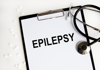 Conceptual image with Epilepsy inscription with the view of stethoscope and notebook on the white...