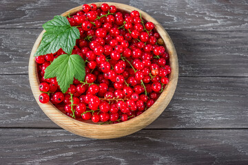 berries of ripe red currant in a wooden bowl macro. background with ripe currant berries close-up. red currant on a wooden background in a bowl.