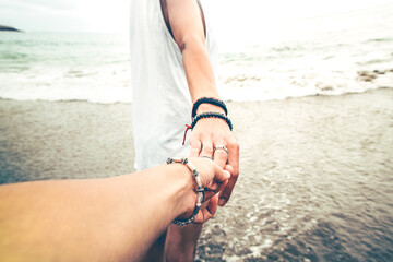 Young couples shaking hands to the sea.