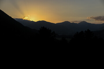 Obraz premium Last rays of sun behind the silhouettes of the mountains, Opi commune, Abruzzo region, Aquila province, Italy