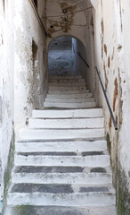 Fototapeta na wymiar Old stone way up staircase in the medieval Amalfi town dwelling in Southern Italy.