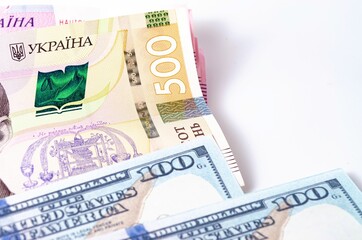 Banknotes Ukrainian hryvnia and dollars on a white background in close-up.