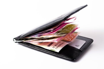 Banknotes Ukrainian hryvnia and dollars on a white background in close-up. Money in a black wallet, money clip Dollars and hryvnia
