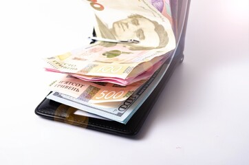 Banknotes Ukrainian hryvnia and dollars on a white background in close-up. Money in a black wallet, money clip Dollars and hryvnia