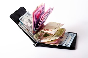 Banknotes Ukrainian hryvnia and dollars on a white background in close-up. Money in a black wallet, money clip Dollars and hryvnia