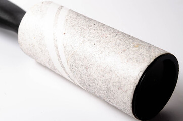 Roller for cleaning clothes on a white background in close-up. A flexible roller for cleaning clothes in a man's hand. Used, dirty clothes roller