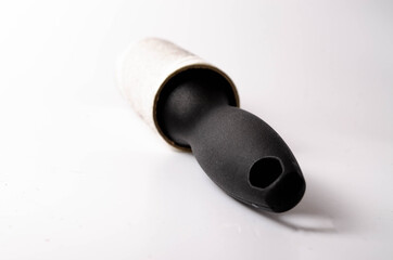 Roller for cleaning clothes on a white background in close-up. A flexible roller for cleaning clothes in a man's hand. Used, dirty clothes roller