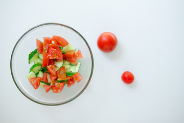 salad with vegetables. summer salad on the table. harvest on a plate. tomato and cucumber are cut into pieces. homemade tomatoes. garden vegetable salad.