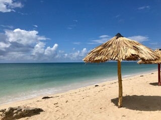 Peaceful and relaxing travel destination in Cuba (Caribbean): Dreamlike Playa Ancon with white sand, turquoise ocean and blue sky is an idyllic vacation paradise