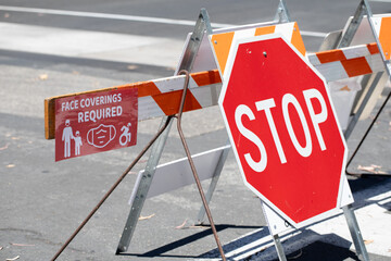 Face covering required warning signs for face masks on public streets during COVID 19 Coronavirus