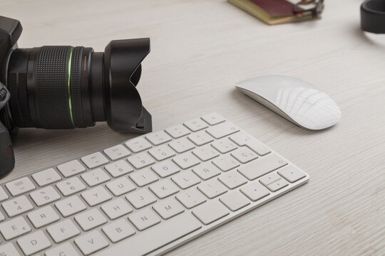 office desk with a professional camera, keyboard and various objects, photographer - photography