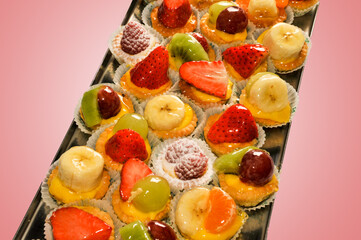 tray with Italian pastries with fruit banana grape raspberry kiwi 