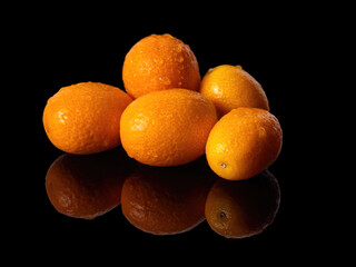 Few fortunella fruits on black