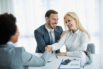 young couple shaking hands deal contract real estate investment business office agreement agent