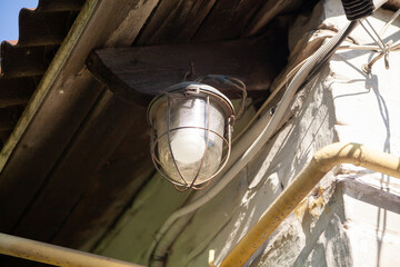 Outdoor luminaire with glass shade weighs on white wall