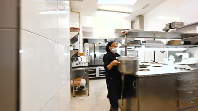 Team of professional chefs preparing and cooking food in a commercial kitchen. POV shot. High quality 4k footage