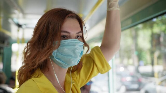 health protection, young woman observes safety precautions in public place and wears medical mask and gloves to protect against virus and infection while riding city bus after removing picture